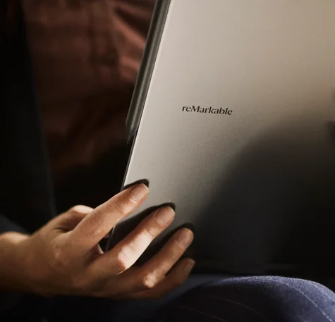 Close-up of a person holding a remarkable tablet, showing the back of the device.