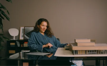 A woman admiring a scale model of a building.